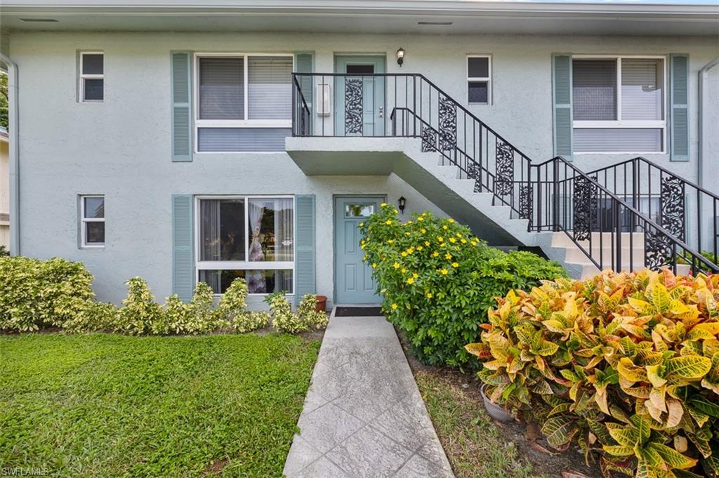 197 Harrison Road, Unit 3 Naples, FL 34112 - Photo 1 of 14 Doorway to property featuring stucco siding and a lawn