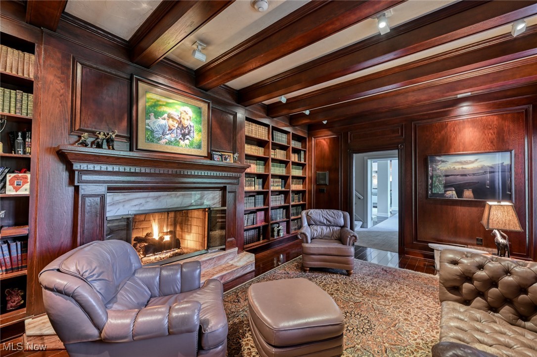 4950 West Streetsboro Road Richfield, OH 44286 - Photo 7 of 27 Sitting room featuring built in shelves, wood walls, crown molding, and beam ceiling