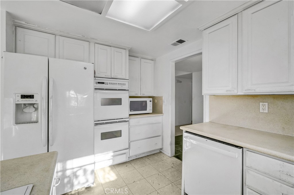 23141 Tulip Street Lake Forest, CA 92630 - Photo 5 of 27 a kitchen with stainless steel appliances a refrigerator sink and cabinets
