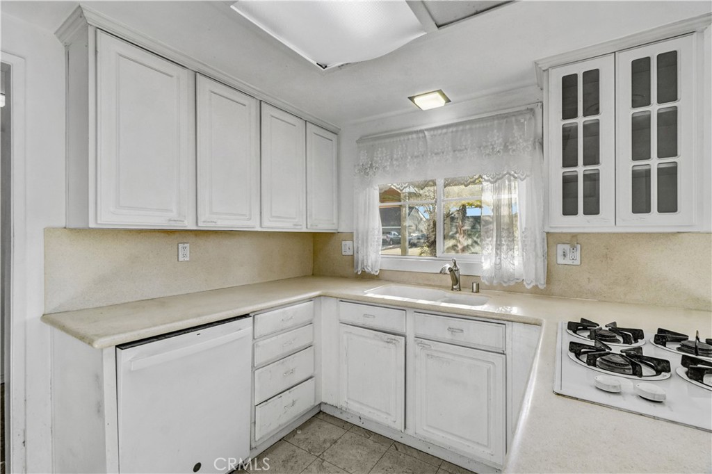 23141 Tulip Street Lake Forest, CA 92630 - Photo 6 of 27 a kitchen with white cabinets and white appliances