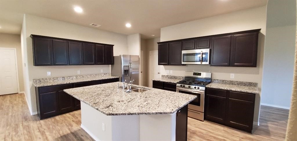 7723 London Tower Lane Houston, TX 77044 - Photo 3 of 11 a kitchen with granite countertop stainless steel appliances a stove sink microwave and cabinets