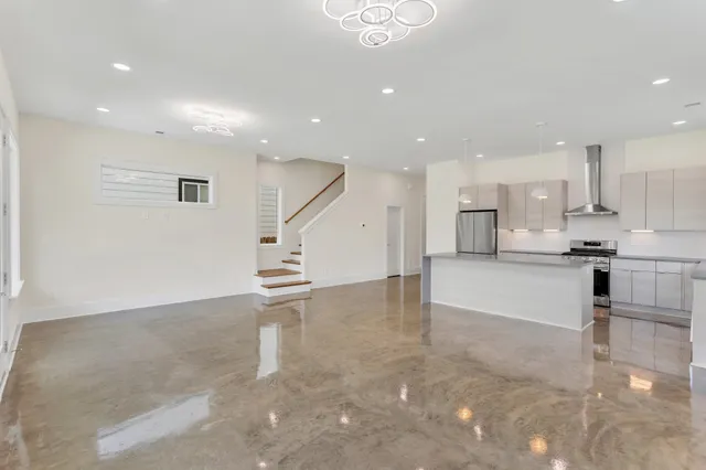 a view of kitchen with kitchen island white cabinets and stainless steel appliances