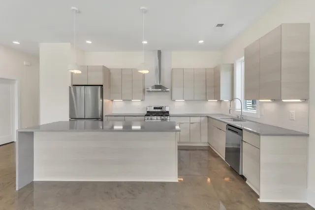 a large kitchen with stainless steel appliances lots of counter space and a sink
