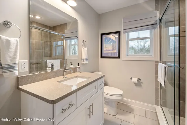 a bathroom with a sink a toilet and a large mirror