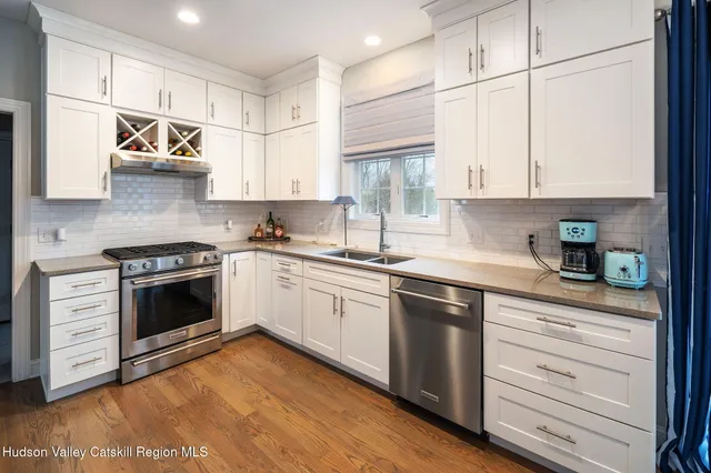 a kitchen with stainless steel appliances granite countertop a sink a stove and cabinets