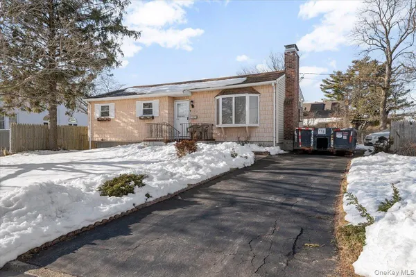 a front view of a house with a yard covered in snow