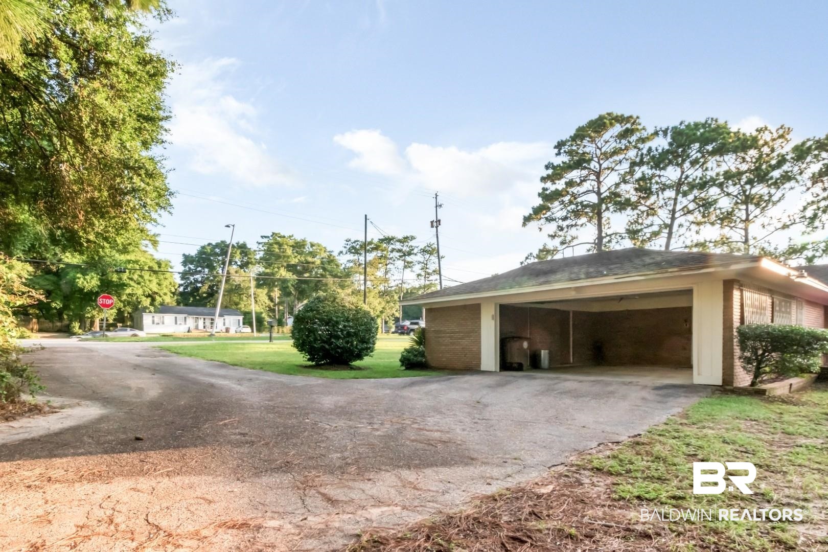 241 Suzanne Circle Mobile, AL 36608 - Photo 35 of 41 View of property exterior featuring driveway, brick siding, an outdoor structure, and a lawn