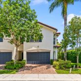 a front view of a house with a yard and tree