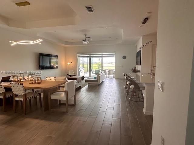 5545 Hampton Links Court, Unit 5545 Ave Maria, FL 34142 - Photo 15 of 28 a view of a dining room and livingroom with furniture wooden floor a rug a painting and a chandelier