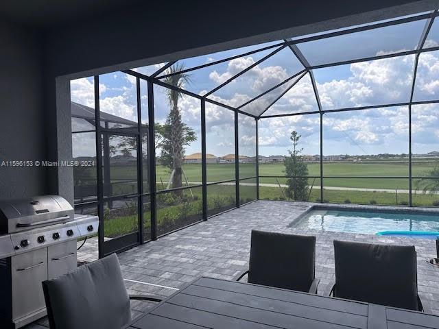 5545 Hampton Links Court, Unit 5545 Ave Maria, FL 34142 - Photo 24 of 28 a living room with furniture and floor to ceiling windows