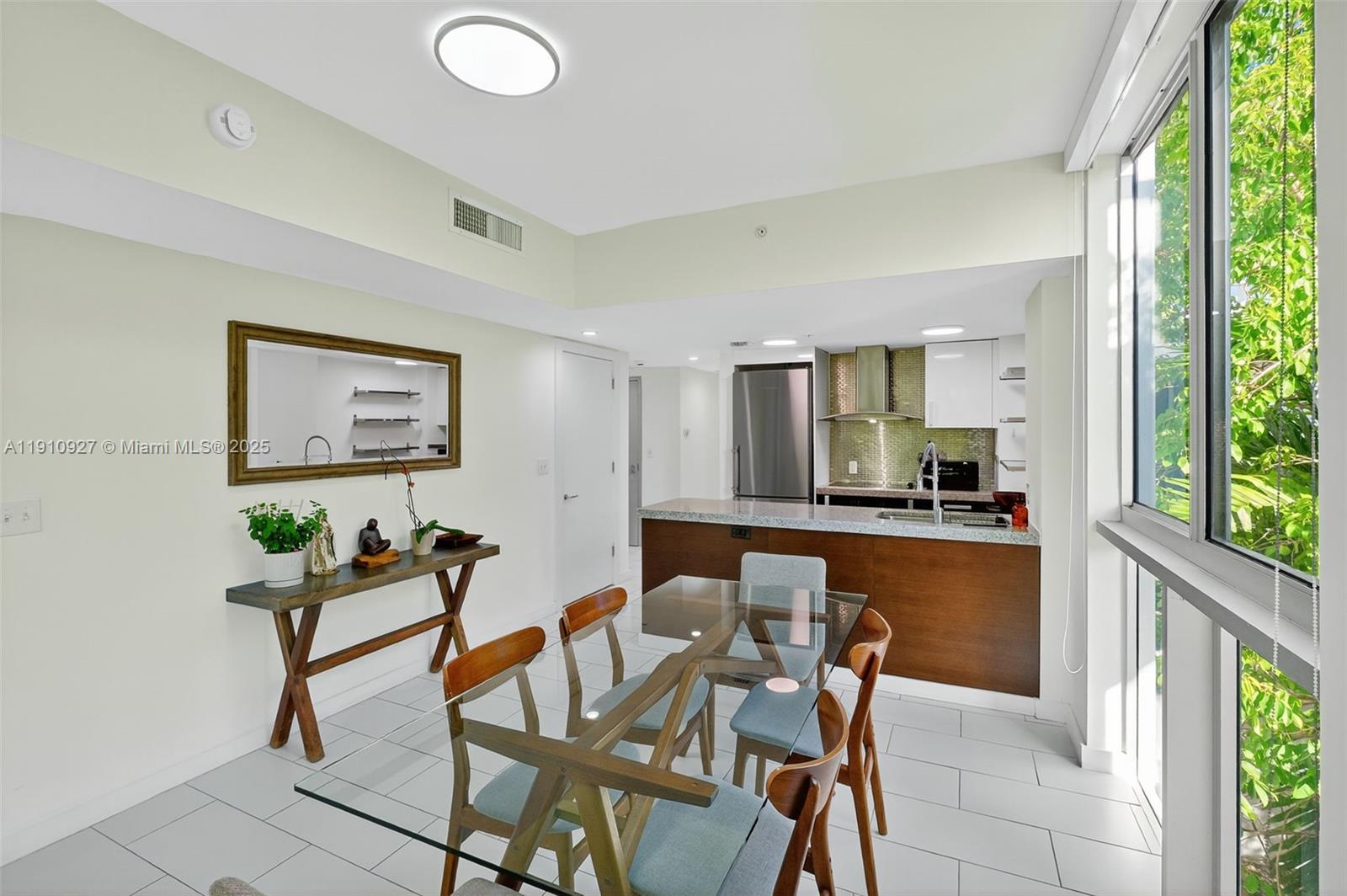 720 Northeast 62nd Street, Unit 311 Miami, FL 33138 - Photo 11 of 39 a living room with furniture a large window and dining space