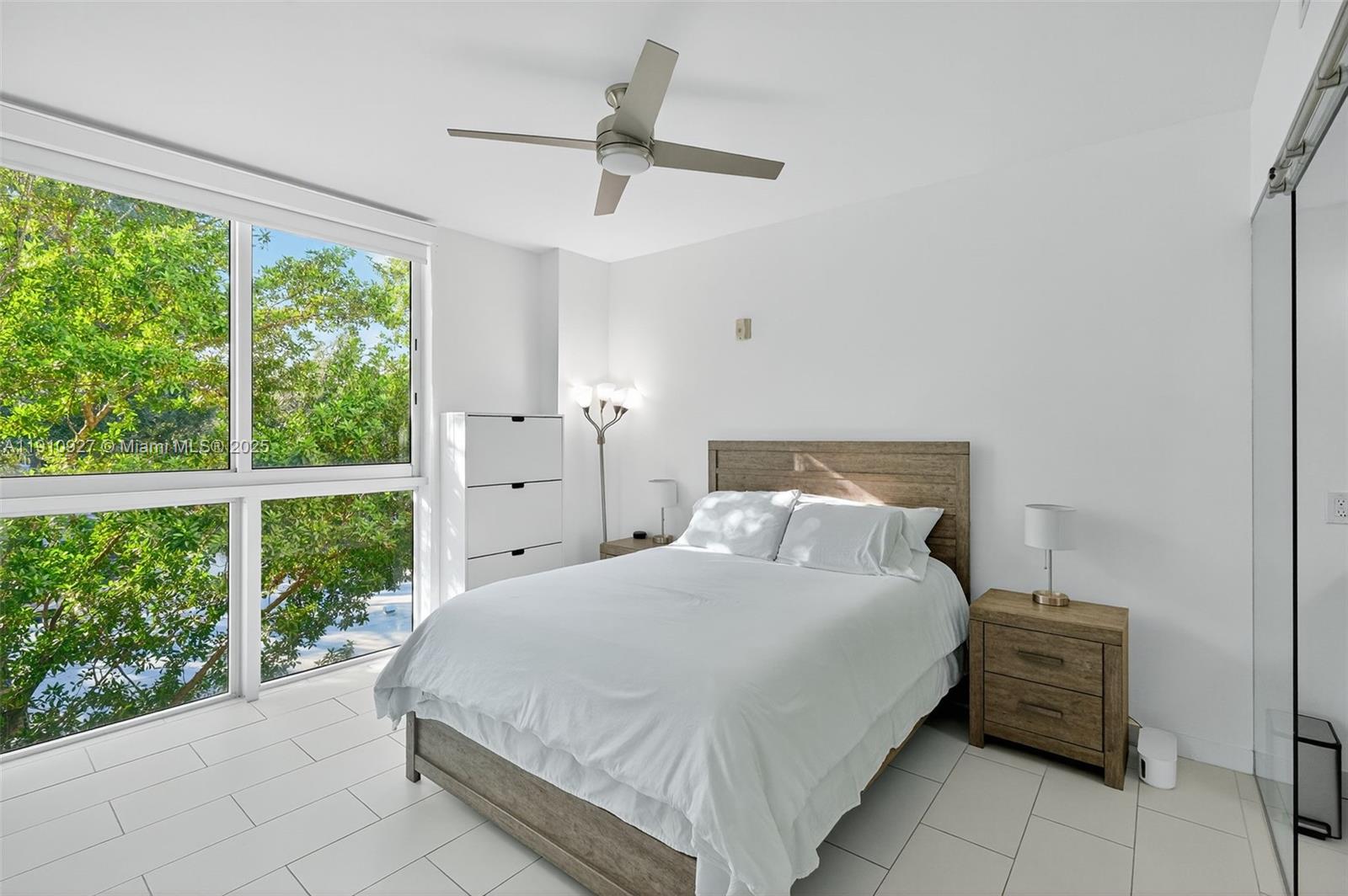 720 Northeast 62nd Street, Unit 311 Miami, FL 33138 - Photo 15 of 39 a bedroom with a large bed and a large window