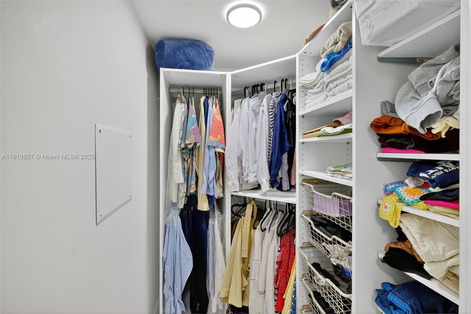 720 Northeast 62nd Street, Unit 311 Miami, FL 33138 - Photo 19 of 39 a view of walk in closet with clothes and shoes