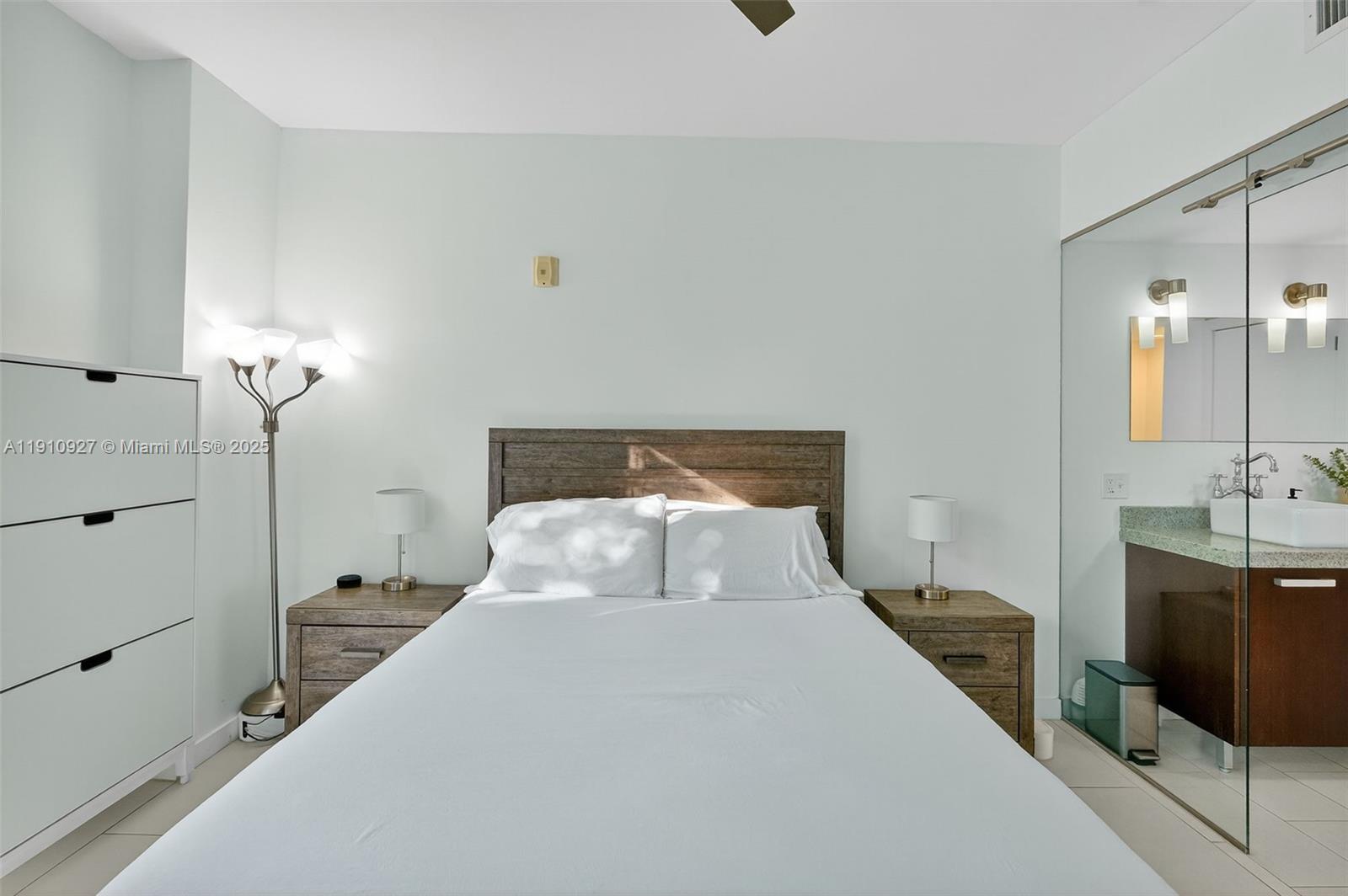 720 Northeast 62nd Street, Unit 311 Miami, FL 33138 - Photo 20 of 39 a bedroom with a large bed and a chandelier