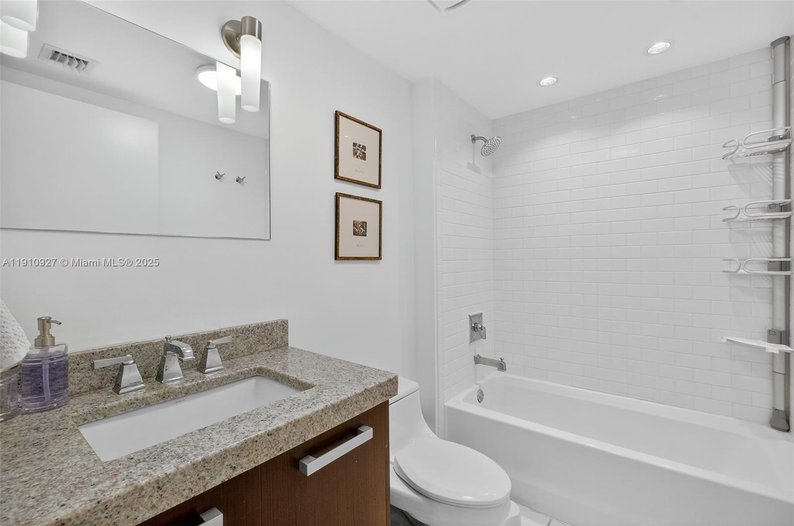 720 Northeast 62nd Street, Unit 311 Miami, FL 33138 - Photo 26 of 39 a bathroom with a granite countertop sink a toilet and bathtub