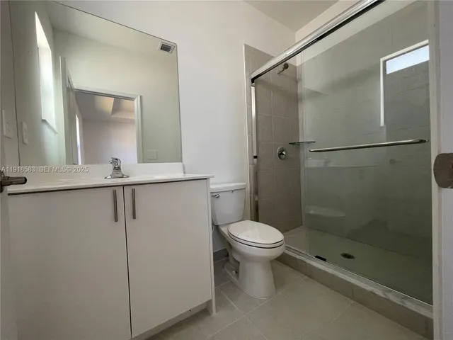 a bathroom with a shower a toilet and a sink