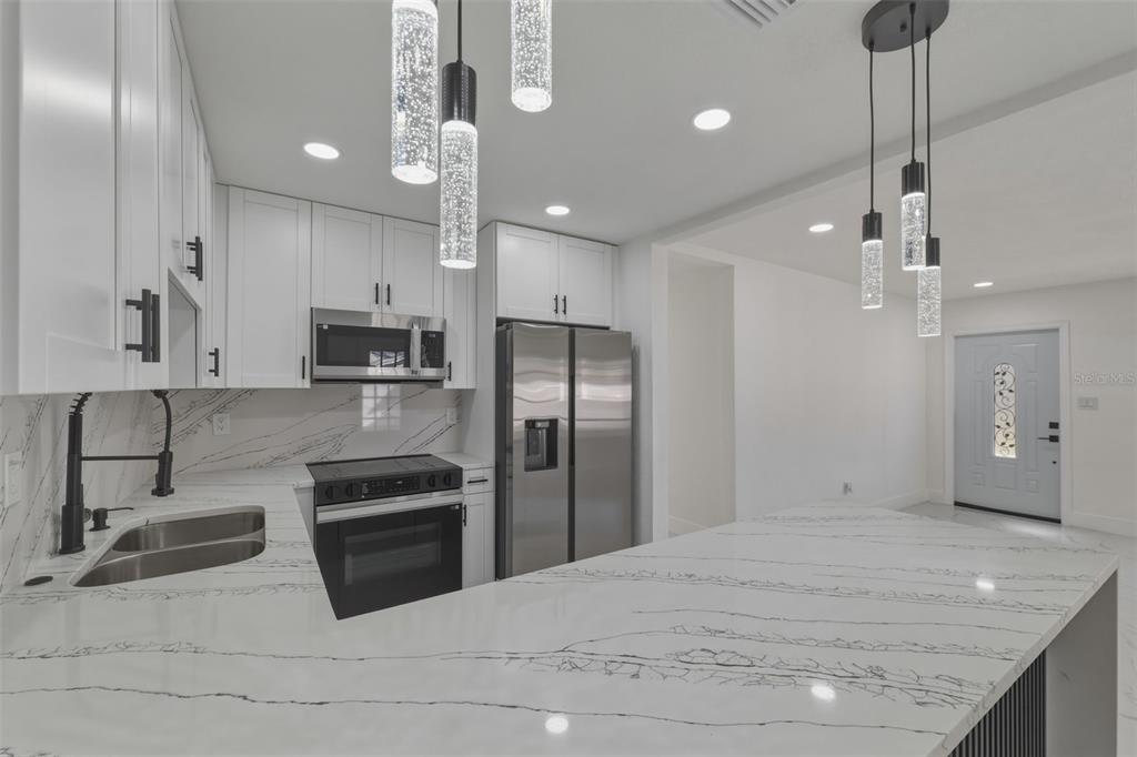 1413 May Street Lutz, FL 33548 - Photo 12 of 43 a kitchen with stainless steel appliances granite countertop a sink a stove and a refrigerator