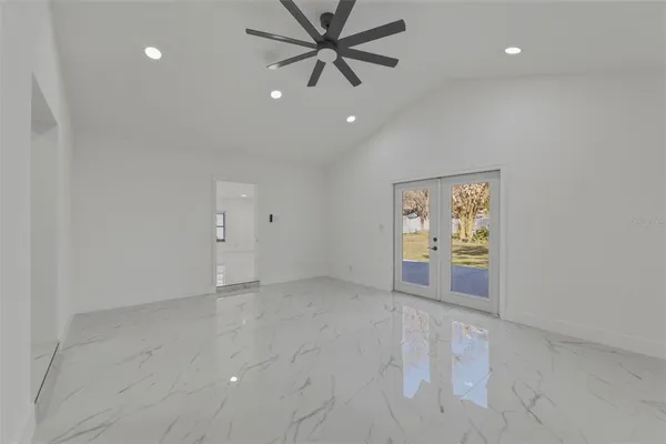 an empty room with windows and ceiling fan
