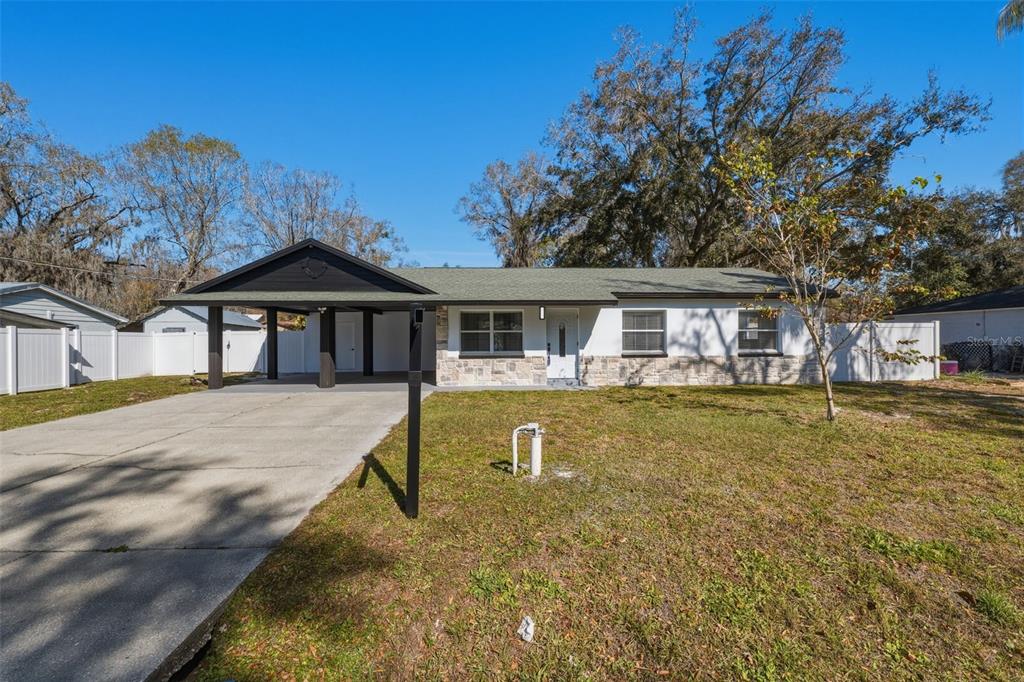 1413 May Street Lutz, FL 33548 - Photo 6 of 43 a front view of a house with a yard glass top table and chairs