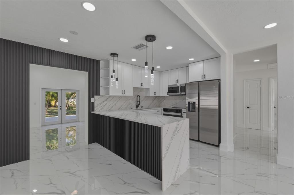 1413 May Street Lutz, FL 33548 - Photo 9 of 43 a kitchen with stainless steel appliances kitchen island granite countertop a refrigerator and a sink