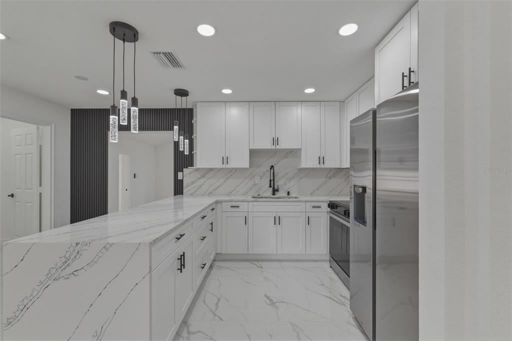 1413 May Street Lutz, FL 33548 - Photo 10 of 43 a kitchen with stainless steel appliances kitchen island granite countertop a refrigerator and a sink