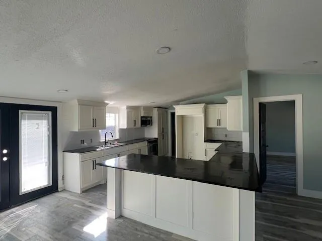 a kitchen with stainless steel appliances granite countertop a sink and cabinets
