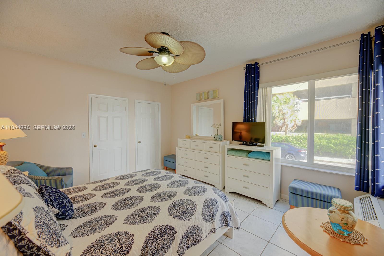 326 Harrison Street, Unit 106A Hollywood, FL 33019 - Photo 11 of 22 a bedroom with a bed and a chandelier
