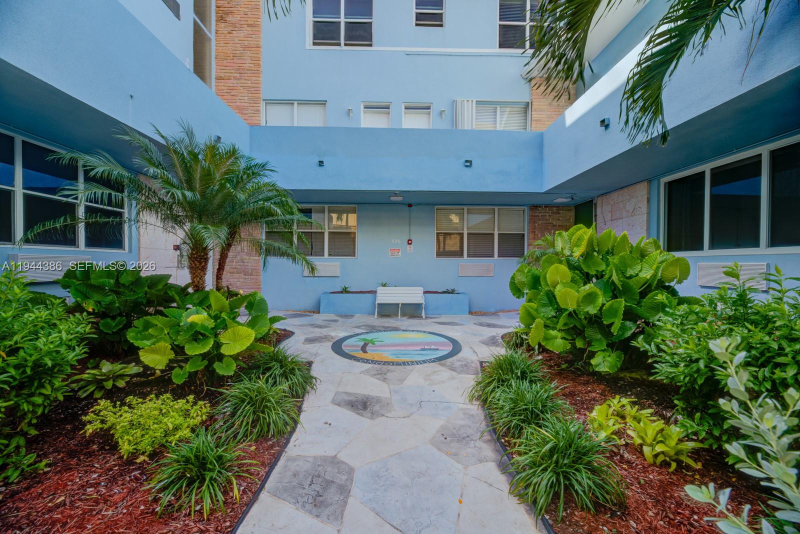 326 Harrison Street, Unit 106A Hollywood, FL 33019 - Photo 21 of 22 a front view of a house with garden and lots of green space