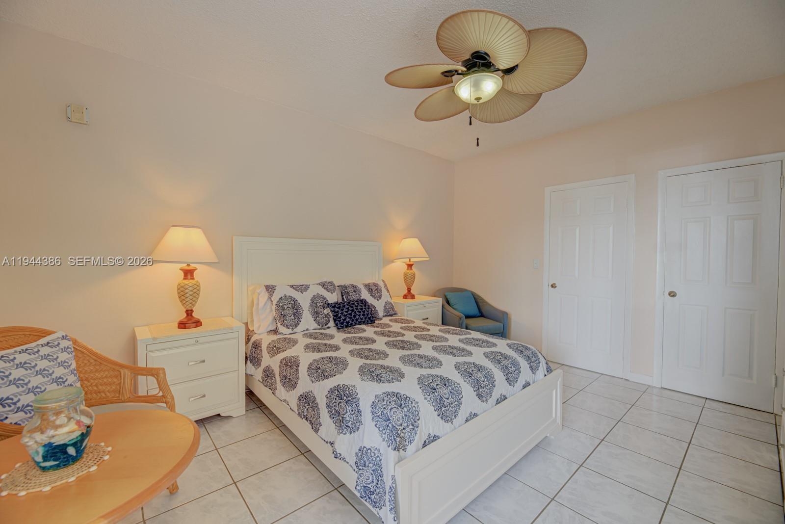 326 Harrison Street, Unit 106A Hollywood, FL 33019 - Photo 10 of 22 a bedroom with a bed and a chandelier
