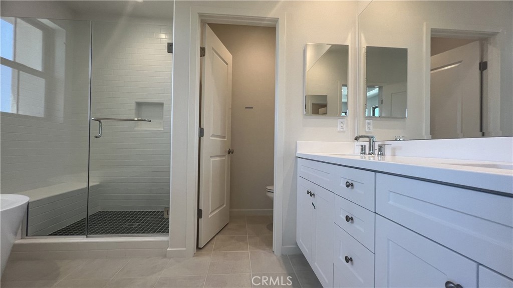110 Sunnyside Irvine, CA 92618 - Photo 19 of 30 a bathroom with a shower sink and mirror