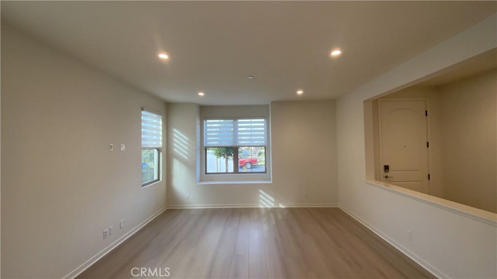 110 Sunnyside Irvine, CA 92618 - Photo 5 of 30 an empty room with wooden floor and windows
