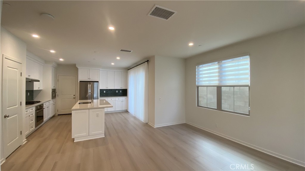 110 Sunnyside Irvine, CA 92618 - Photo 6 of 30 a living room with stainless steel appliances furniture a refrigerator a kitchen and a sink