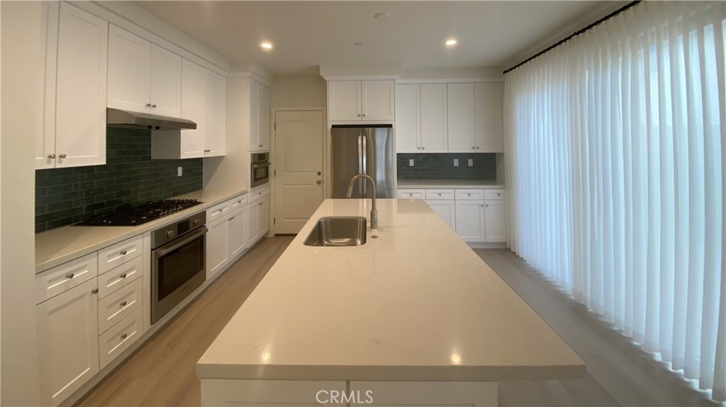 110 Sunnyside Irvine, CA 92618 - Photo 7 of 30 a kitchen with stainless steel appliances a refrigerator sink and stove