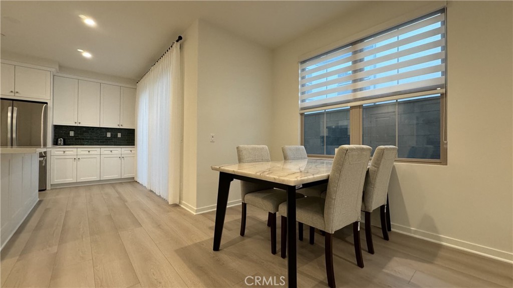 110 Sunnyside Irvine, CA 92618 - Photo 8 of 30 a kitchen with stainless steel appliances kitchen island granite countertop a table chairs sink and cabinets