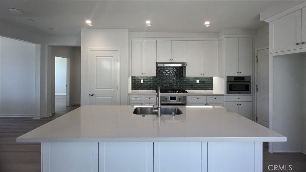 110 Sunnyside Irvine, CA 92618 - Photo 9 of 30 a kitchen with stainless steel appliances a stove a sink a microwave a refrigerator and cabinets