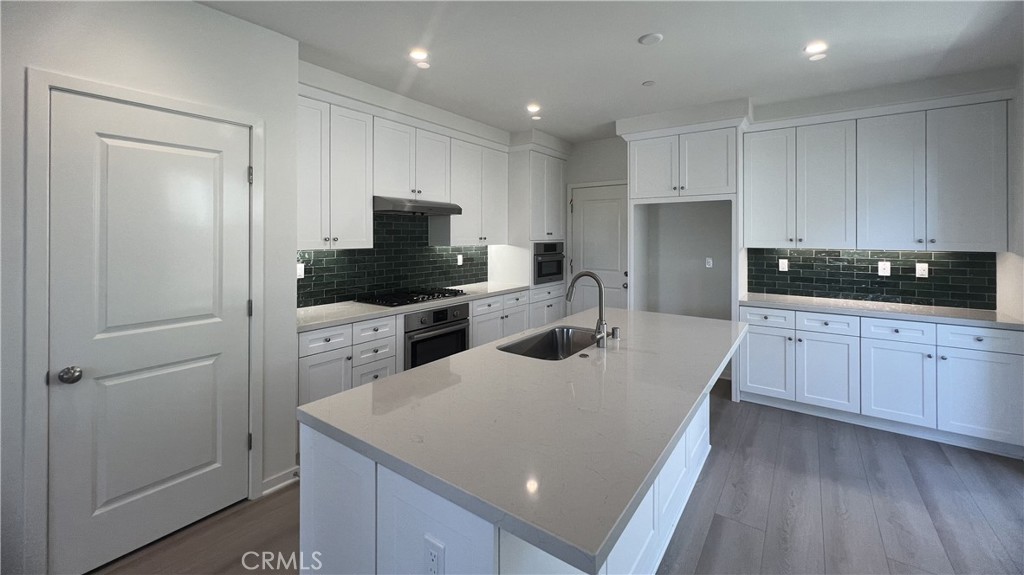 110 Sunnyside Irvine, CA 92618 - Photo 10 of 30 a kitchen with a sink a microwave a refrigerator and cabinets