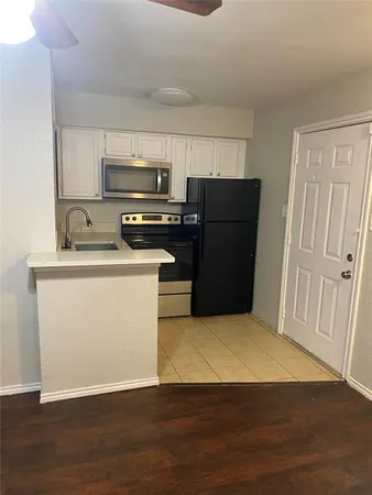 a kitchen with a refrigerator sink and wooden floor