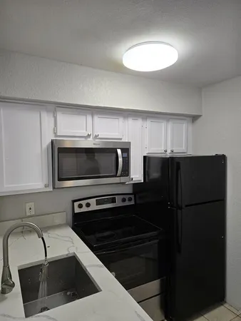 a kitchen with a refrigerator sink and microwave