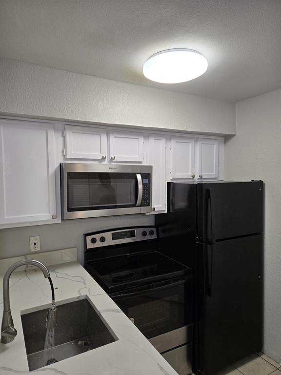 9821 Walnut Street, Unit 304 Dallas, TX 75243 - Photo 15 of 15 a kitchen with a refrigerator sink and microwave