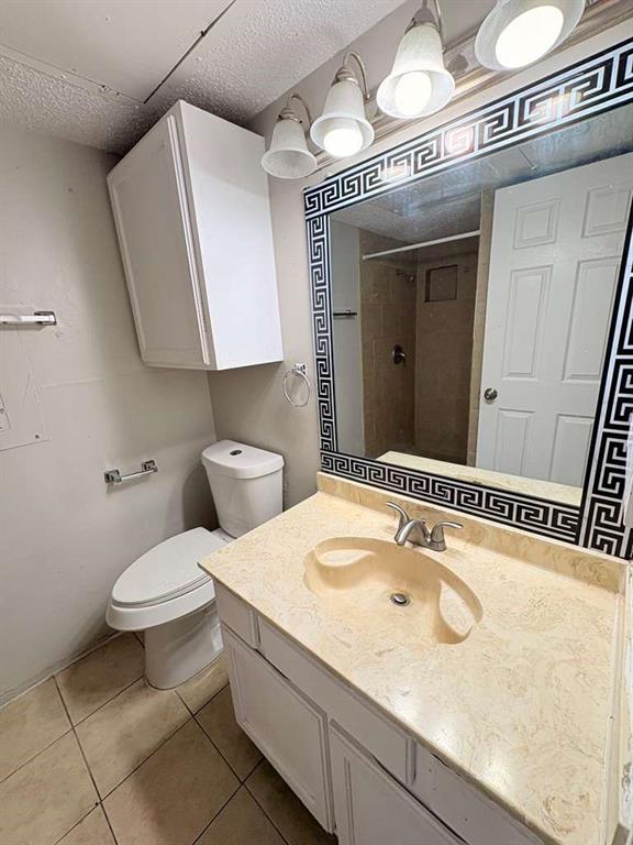 9821 Walnut Street, Unit 304 Dallas, TX 75243 - Photo 2 of 15 a bathroom with a sink a toilet and mirror
