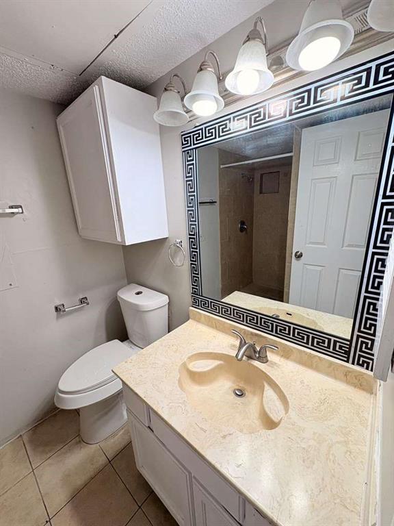 9821 Walnut Street, Unit 304 Dallas, TX 75243 - Photo 8 of 15 a bathroom with a granite countertop sink a toilet and a mirror