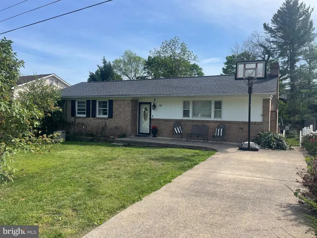 a front view of a house with a garden and yard