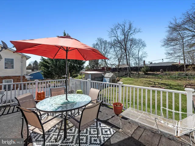 a patio with glass top table and chairs