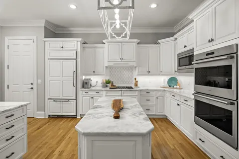 a kitchen with kitchen island white cabinets stainless steel appliances and sink