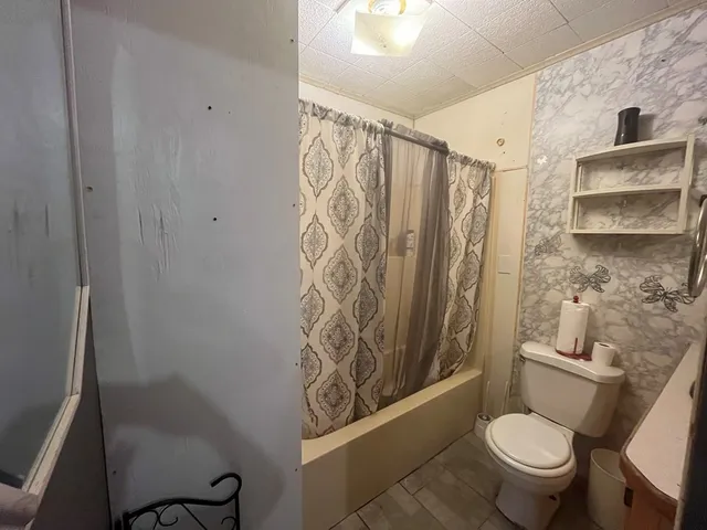 a bathroom with a toilet and a shower