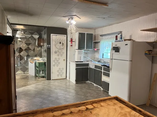 a kitchen with stainless steel appliances granite countertop a refrigerator and a sink