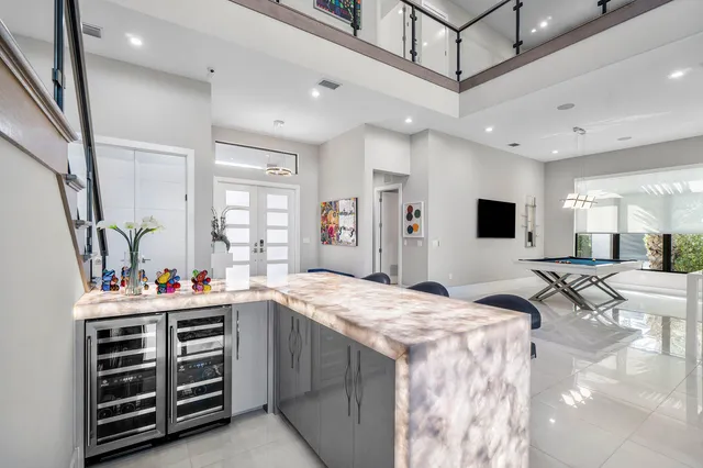 a kitchen with stainless steel appliances kitchen island granite countertop a table chairs sink and cabinets