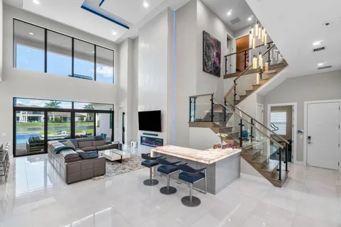 a living room with furniture kitchen view and a large window