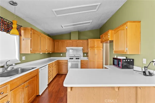 a large kitchen with stainless steel appliances a sink window and a counter top space