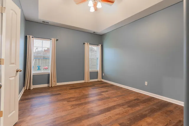 a view of an empty room with window and wooden floor